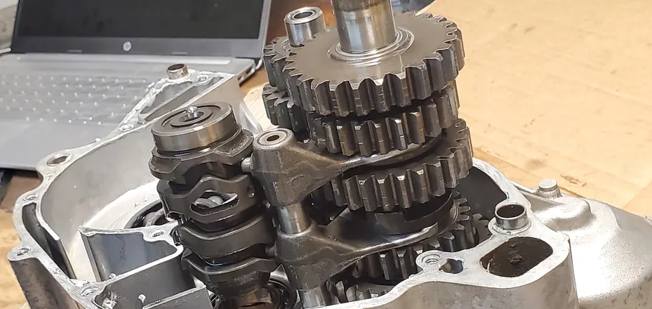 Four-stroke transmission gears and shift drum in the open engine cases