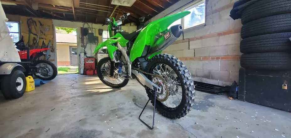 Finished green Kawasaki four-stroke dirt bike in the shop